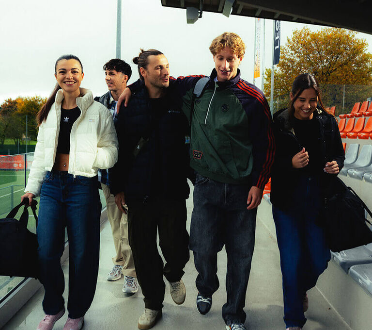 Gruppo di ragazze e ragazzi che vanno allo stadio per allenarsi a calcio